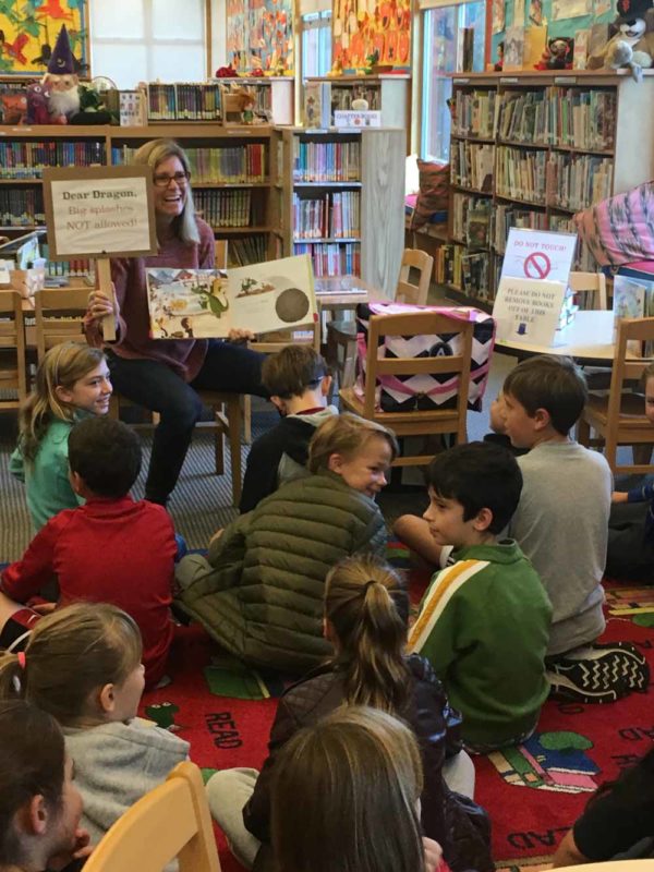 Author Courtney Spain Aragon reading Fraydo the Dragon to a group of children.
